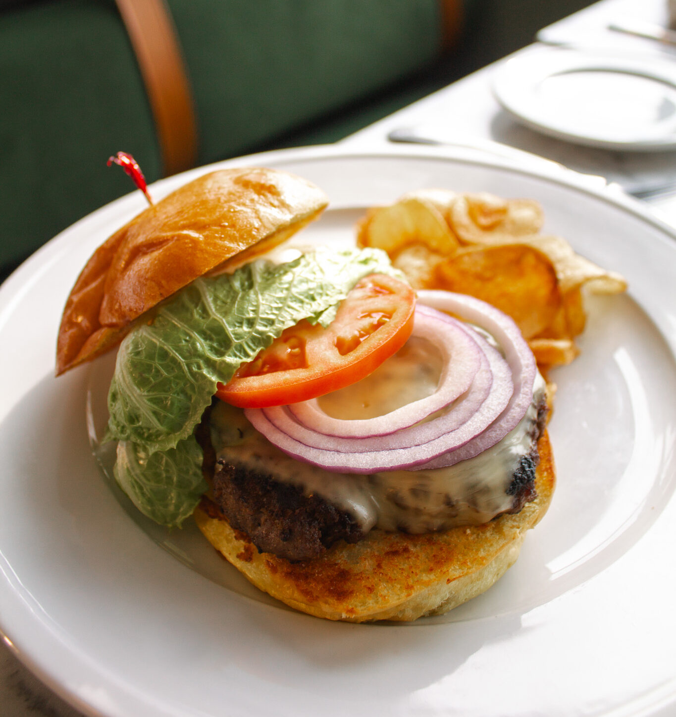 a burger with lettuce, tomato, onion and tomato slices